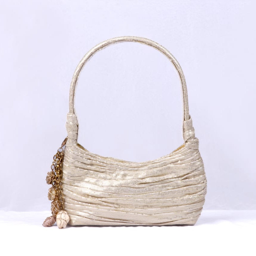 Beige handbag with decorative elements on a light gray background