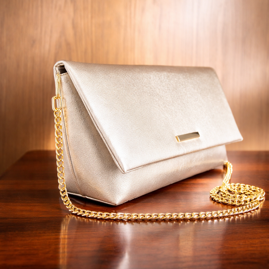 Gold handbag with a chain strap on a wooden surface
