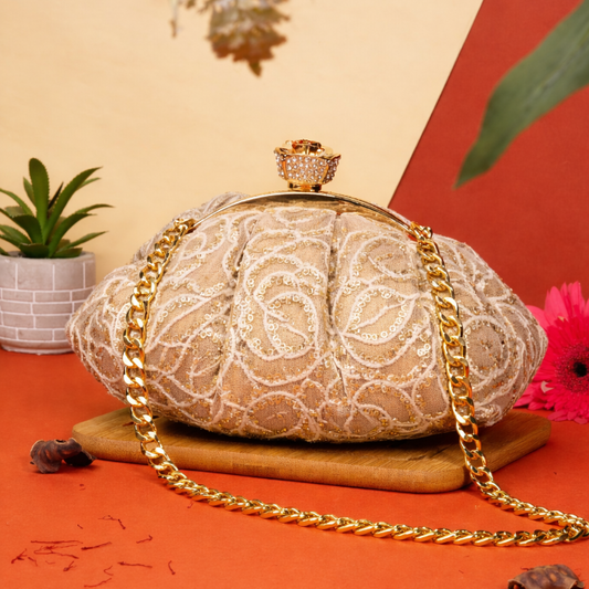 Lace handbag with gold chain on an orange surface with decorative elements
